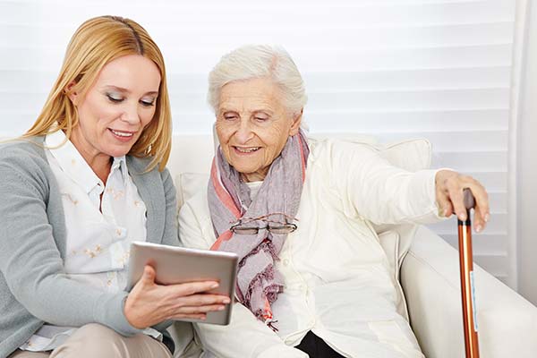 Accessibility - Woman sharing tablet with elderly lady